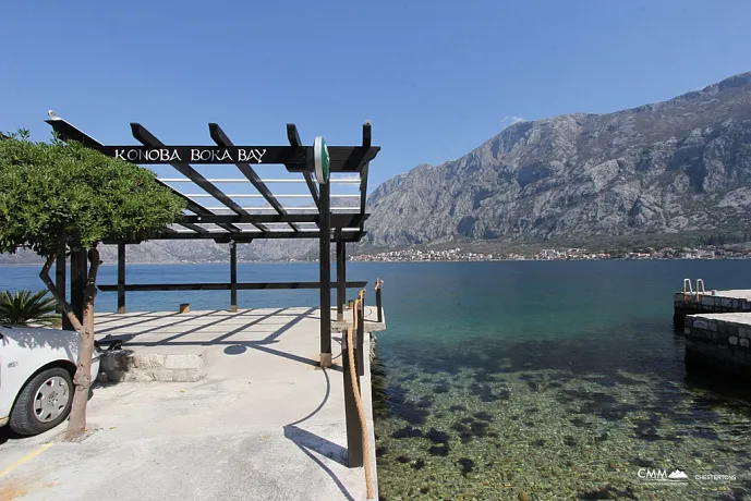 Stone house with a restaurant on the waterfront in Prcanj